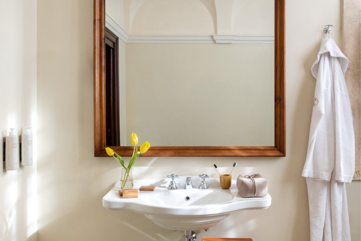Superior room bathroom with classic sink, large mirror and courtesy set in refined Tuscan hospitality style - La Collegiata, BZAR hotels in Tuscany