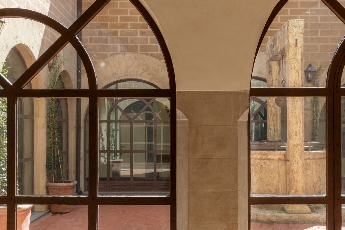 Interior courtyard view with stone arches and central well, typical architecture of a historic Tuscan residence - La Collegiata, BZAR hotels in Tuscany