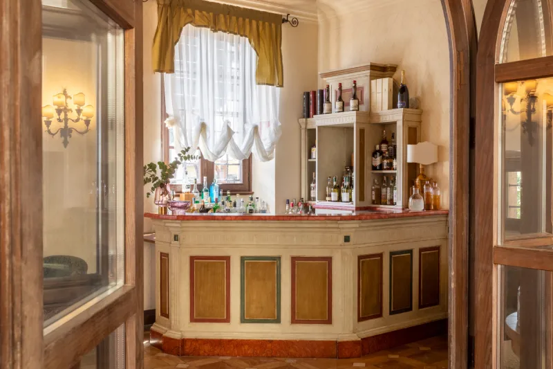 Elegant bar corner with classic counter, selected spirits and natural light in a historic residence near San Gimignano - La Collegiata, BZAR hotels in Tuscany
