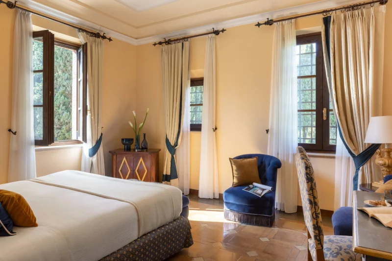 Bright deluxe room with double bed, blue velvet armchair and classic Tuscan-style details - La Collegiata, BZAR hotels in Tuscany