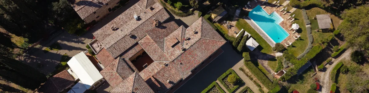 Aerial view of La Collegiata with terracotta roofs, landscaped gardens and panoramic pool near San Gimignano - La Collegiata, BZAR hotels in Tuscany