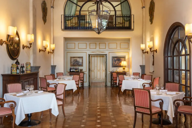 Elegant restaurant with set tables, chandelier and classic details in a historic residence near San Gimignano - La Collegiata, BZAR hotels in Tuscany