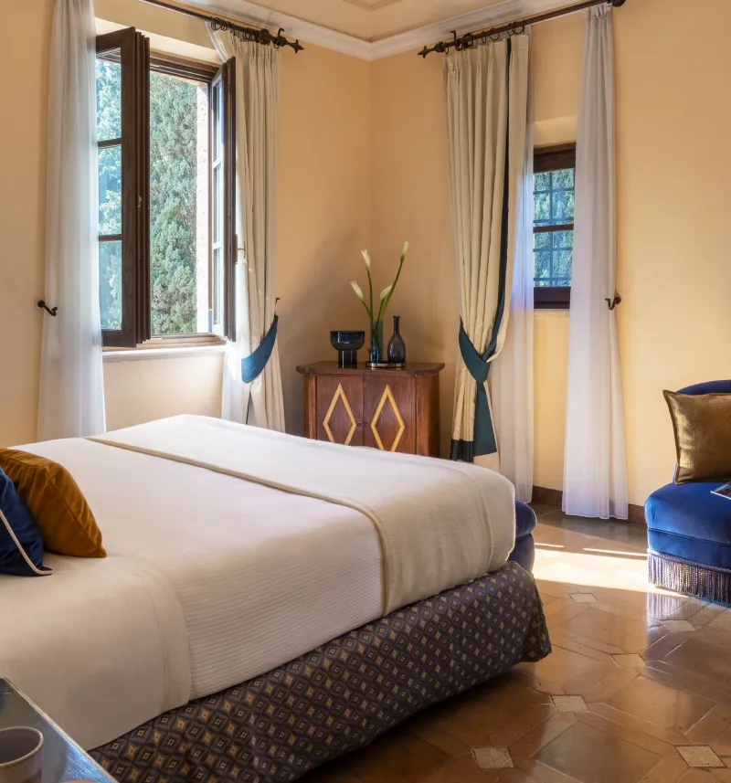 Bright deluxe room with double bed, blue velvet armchair and classic Tuscan-style details - La Collegiata, BZAR hotels in Tuscany