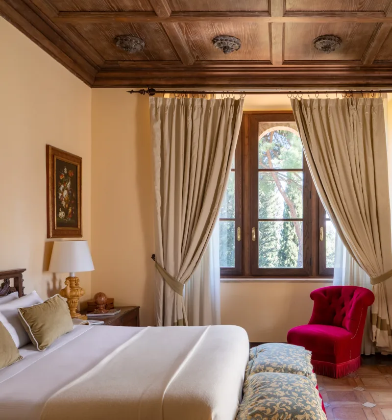 Junior Suite with decorated wooden ceiling, double bed, classic writing desk and red designer armchair - La Collegiata, BZAR hotels in Tuscany