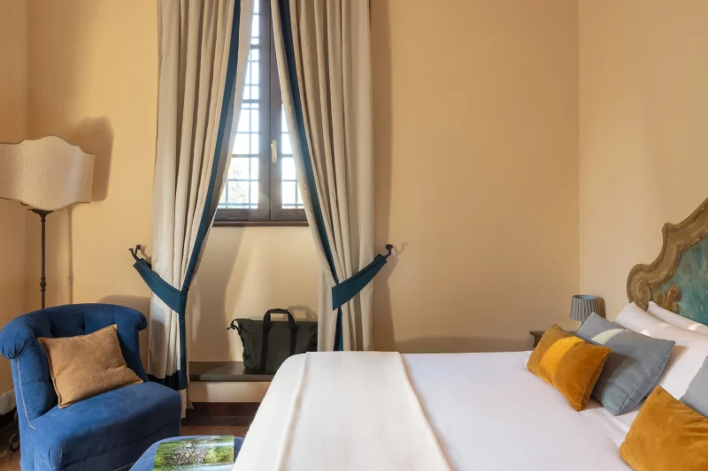 Superior room with double bed, blue armchair, ornate headboard and charming ambiance in the heart of Tuscany - La Collegiata, BZAR hotels in Tuscany