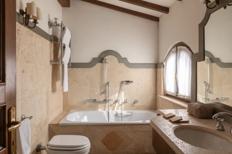 Tower Suite bathroom with bathtub, stone sink and classic finishes in elegant Tuscan style - La Collegiata, BZAR hotels in Tuscany