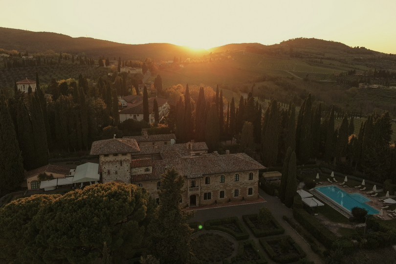 Sunset aerial view of La Collegiata with tower, pool and rolling Tuscan countryside - La Collegiata, BZAR hotels in Tuscany